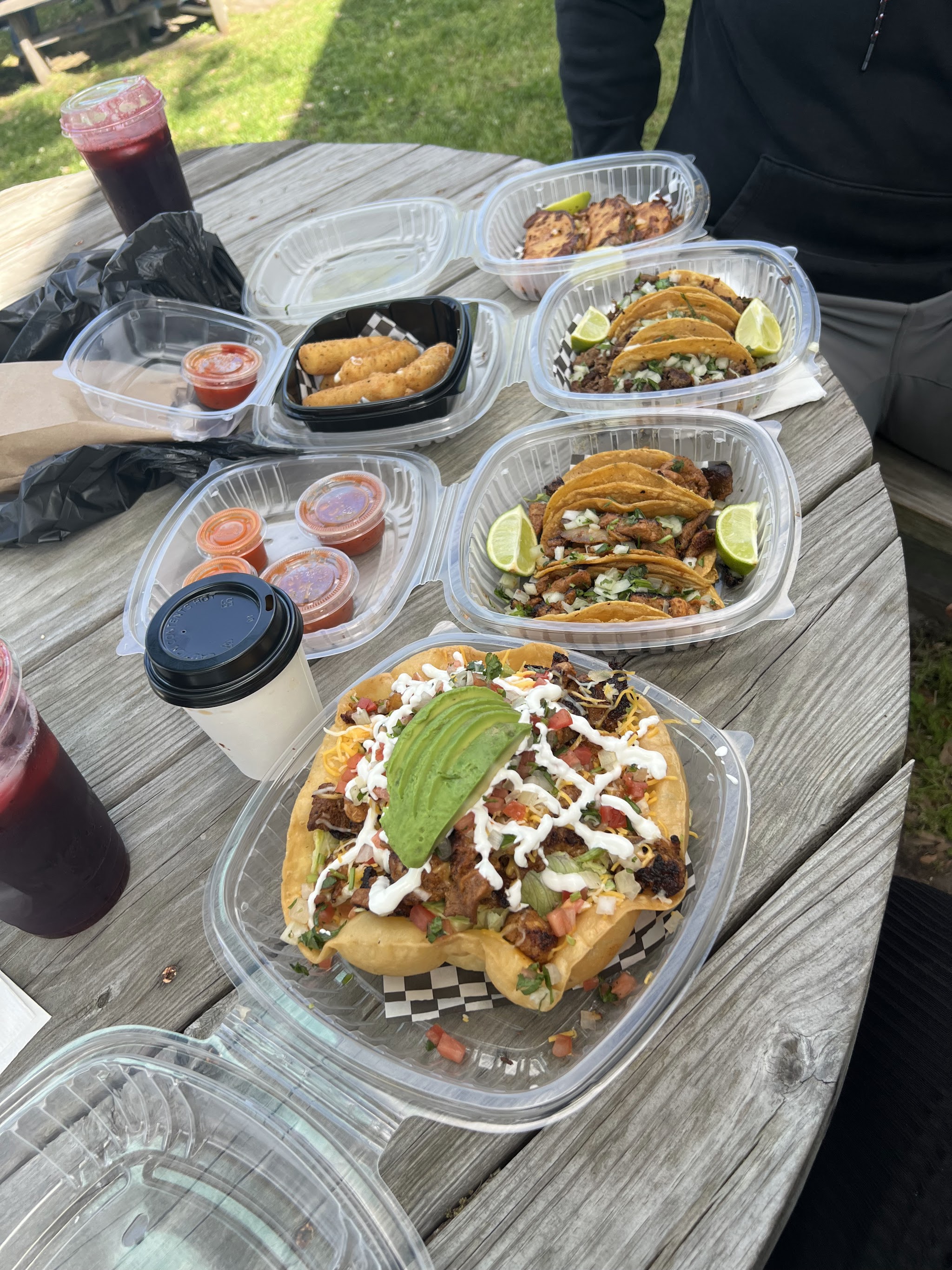 A table spread with tacos, nachos and a coffee
